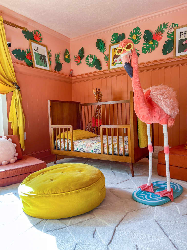 A renovated painted chestnut red nursery with a dark wooden cradle in a