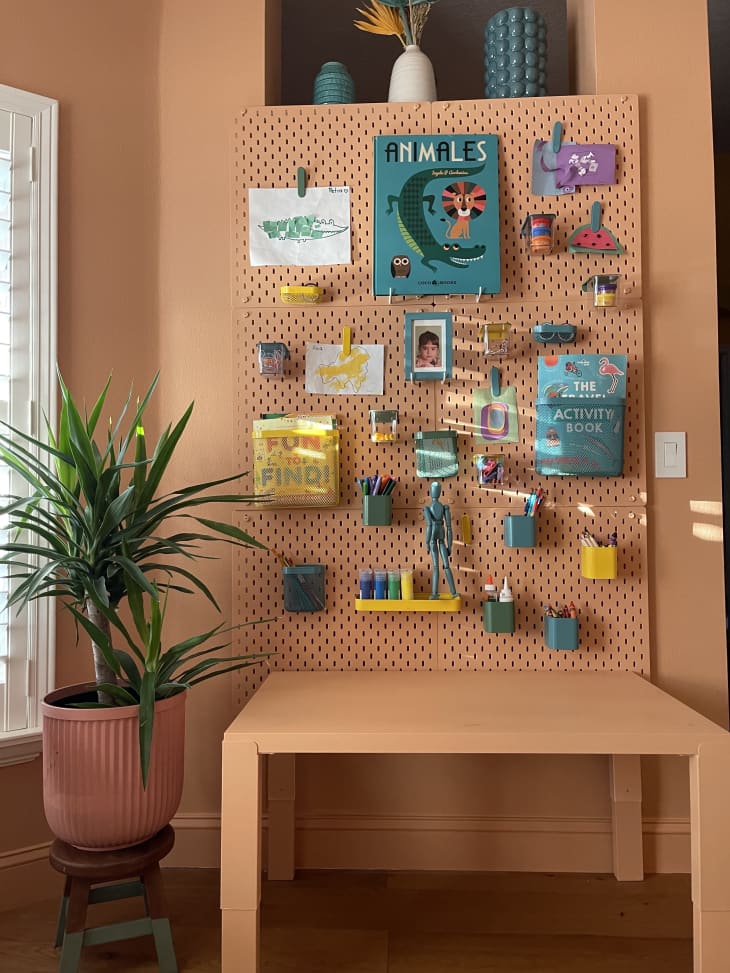A peg board with color matching desk in a playroom.