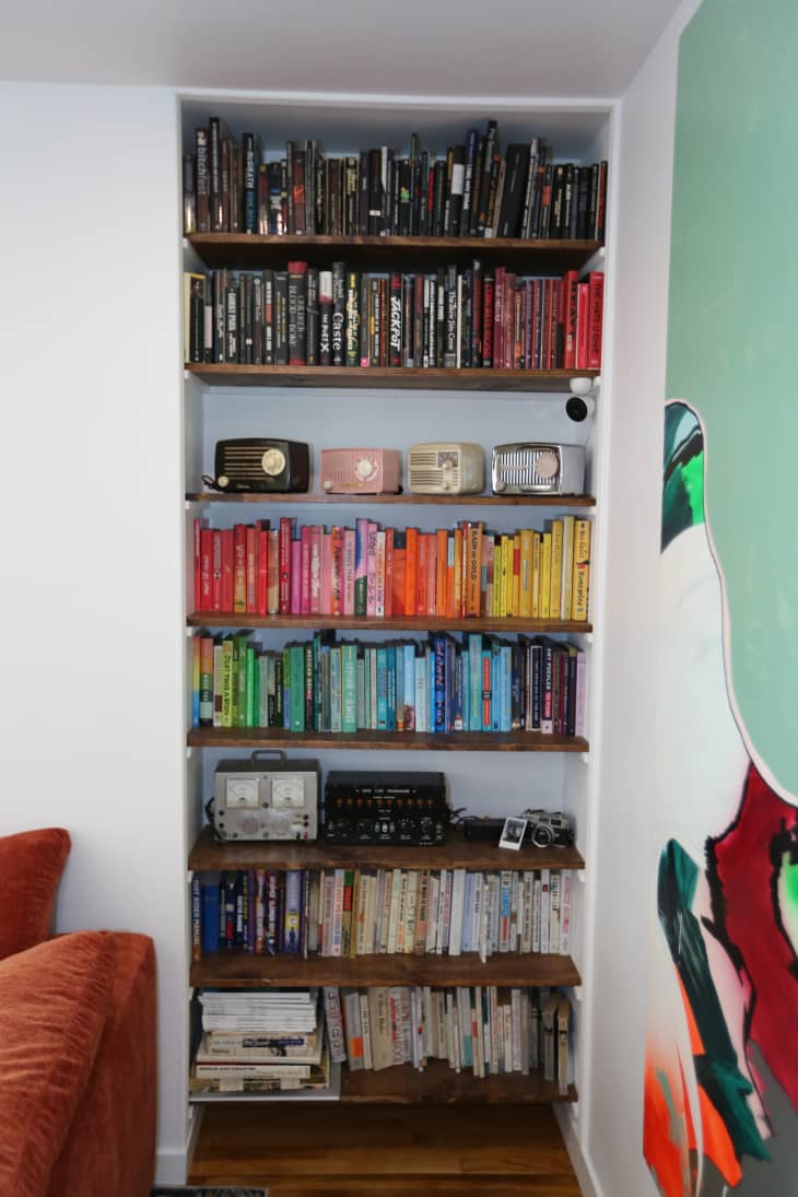 Color coded bookshelf, one shelf is decorated with vintage radios in newly renovated home.