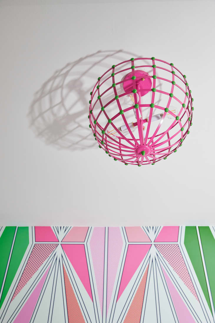 Pink and green globe light fixture on bedroom ceiling.
