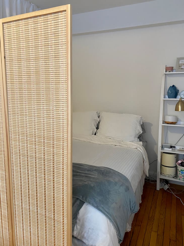 Wicker divider separates bedroom from living space.