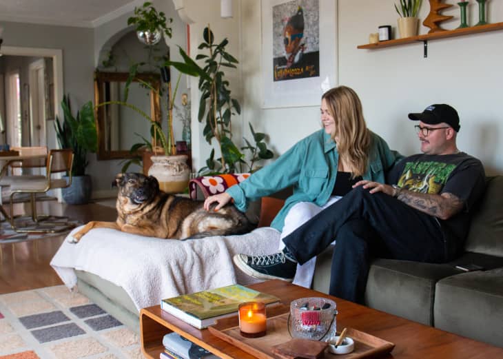 couple with their dog on their living room sofa