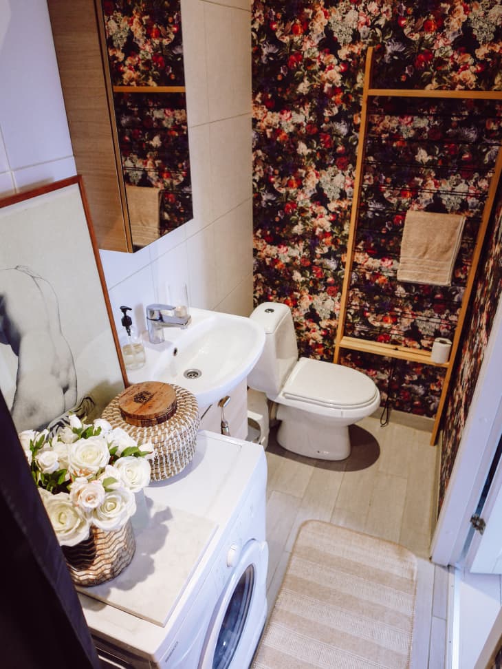 Bathroom with tile walls, floral shower curtain, washing machine