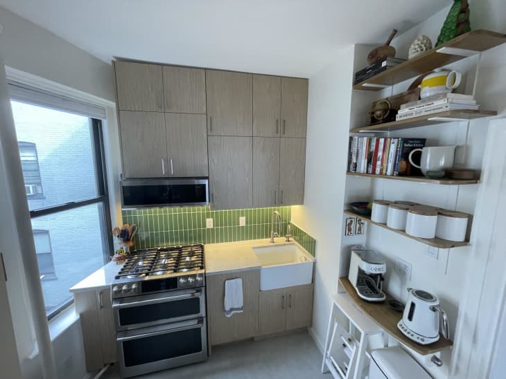 Kitchen with laminate cabinets, green tile backsplash, open shelves