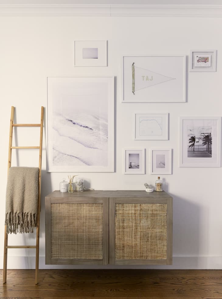 DIY IKEA floating cabinet hack with rattan doors, with white framed art hanging on the wall