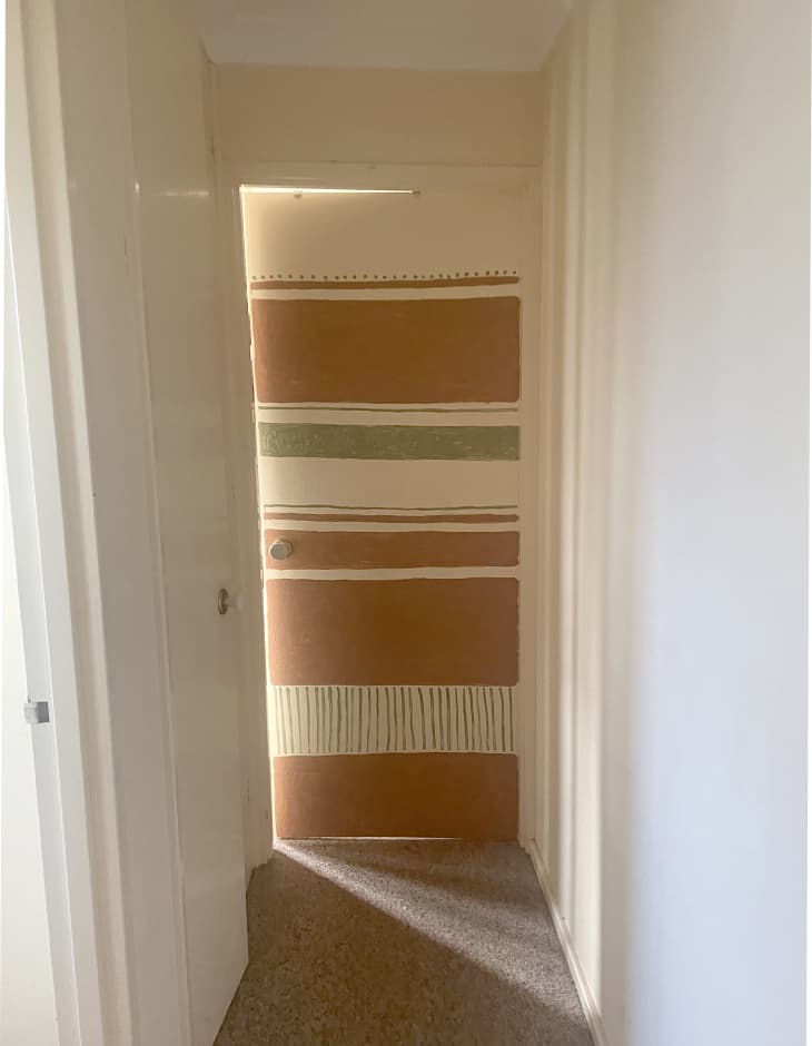 Bedroom door painted in tan and green striped pattern