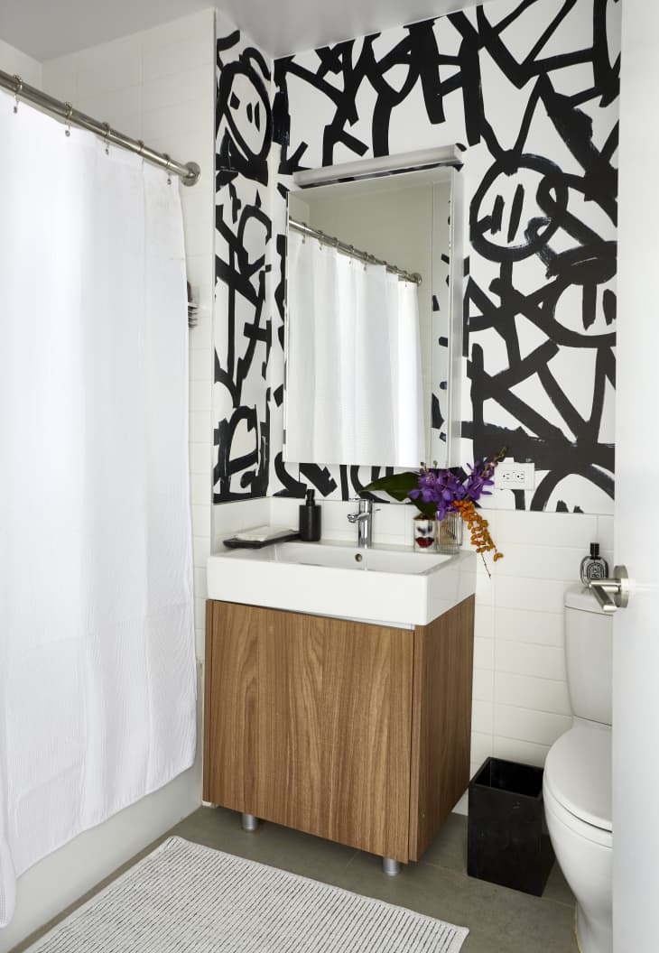 Bathroom with bold black and white wallpaper/art accent wall