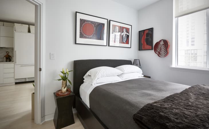 guest bedroom with gray bed, red black and white framed art