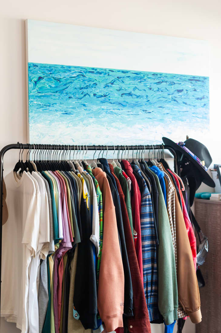 Freestanding clothing rack with lots of clothes on it