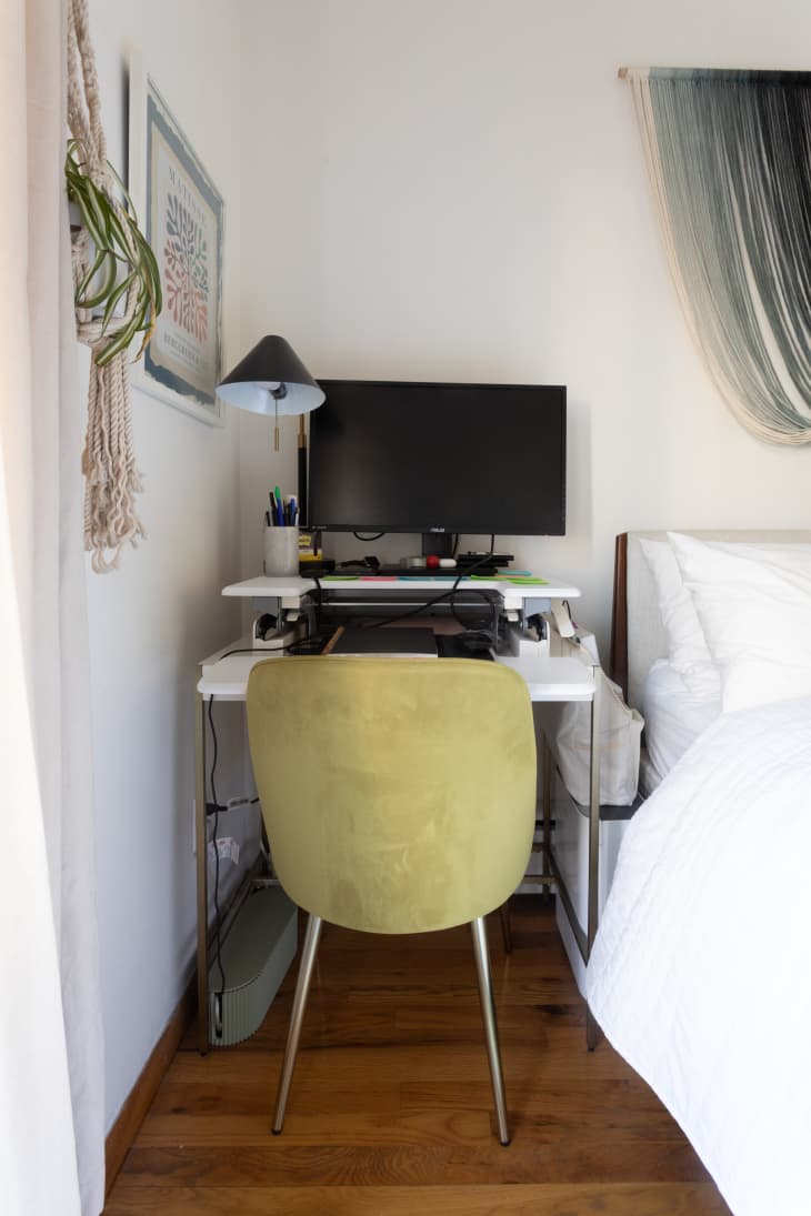 Small desk in corner near bed with celadon chair tucked under.
