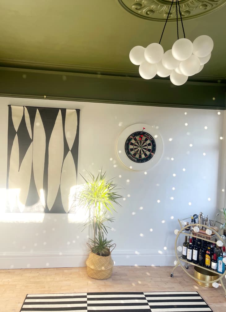 room with green ceiling, off white walls, black and white striped rug, other black and white accents, chandelier that looks like white balloons