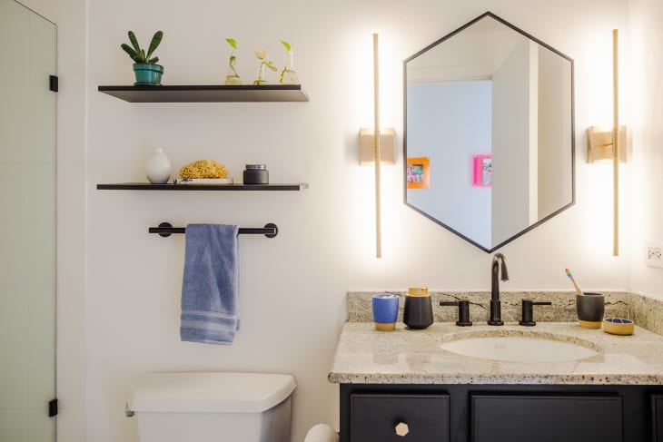 white bathroom with hexagonal mirror, black hardware