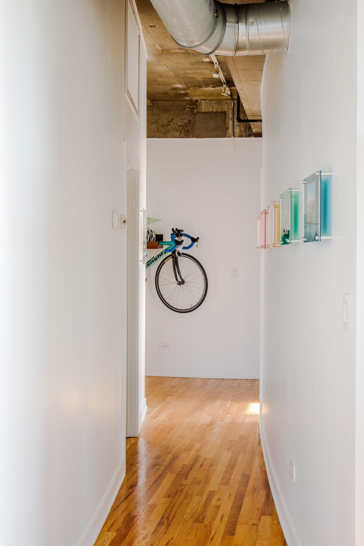 View down white hallway--hanging bicycle seen at the end