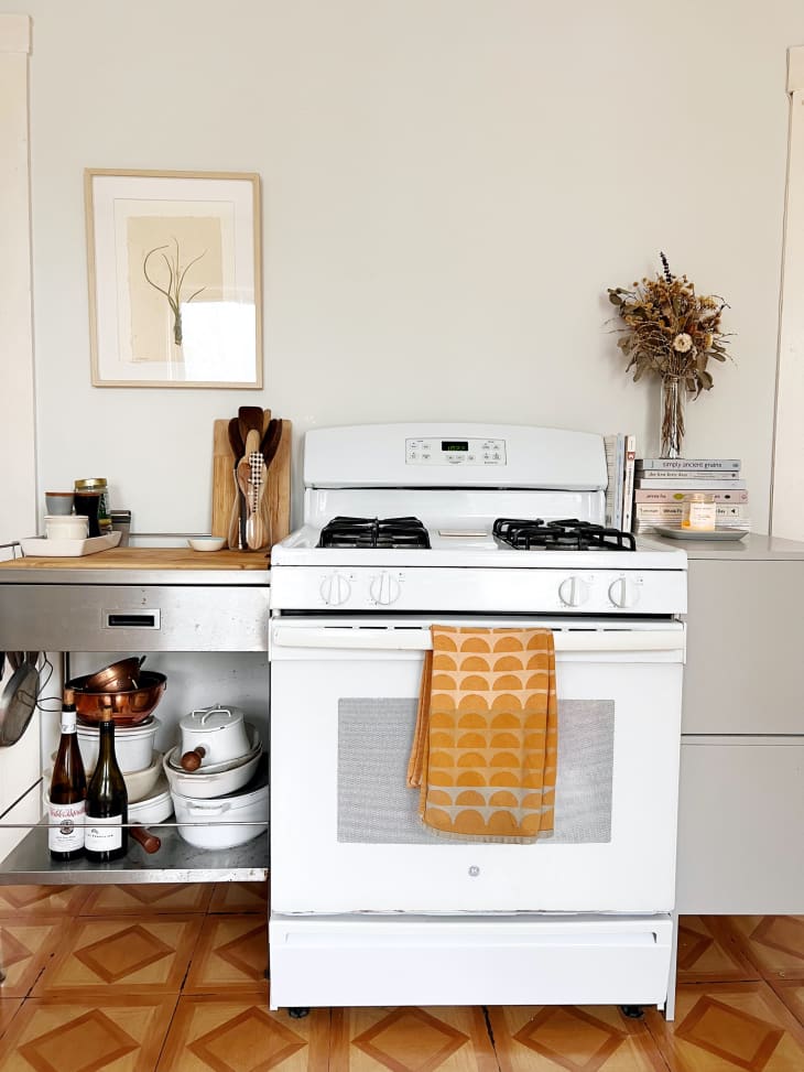 kitchen stove area with warm colored geometric patterned floor, white oven/stove