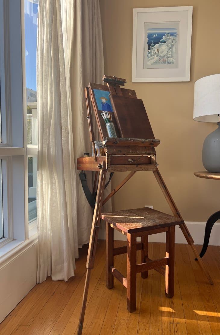 Easel in front of window in studio apartment.