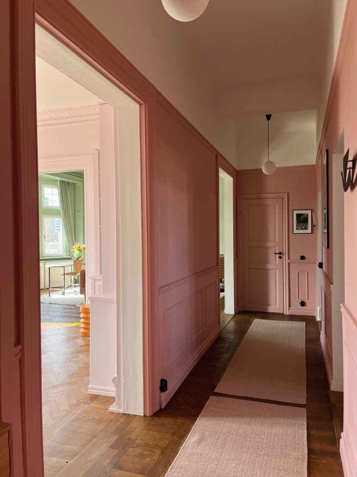 hallway with pink walls, textured runner rugs