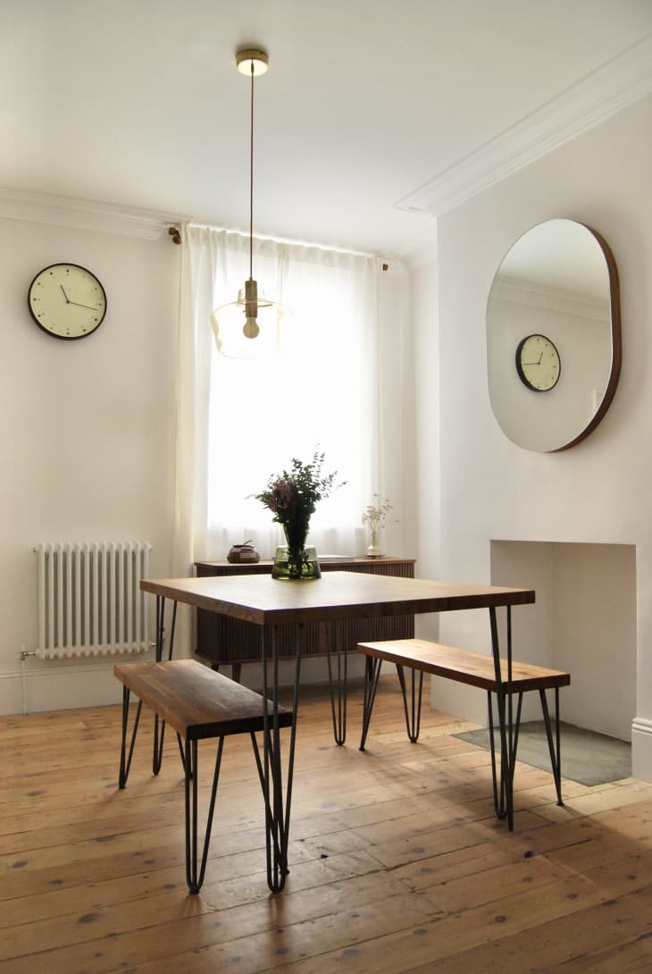 Light filled dining room with rectangular dining table flanked by matching benches.
