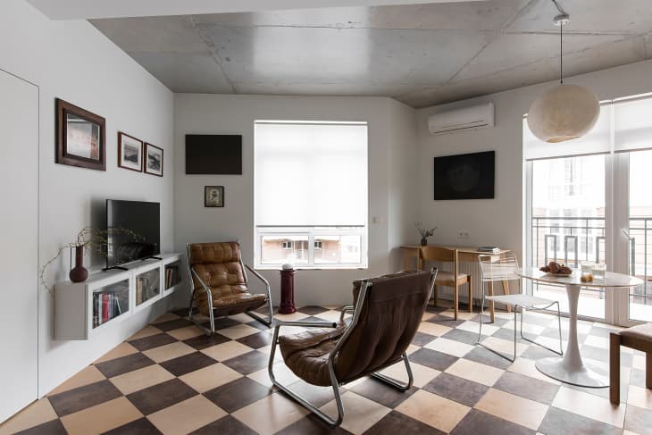 Two brown leather chairs on a checkered floor in the living room