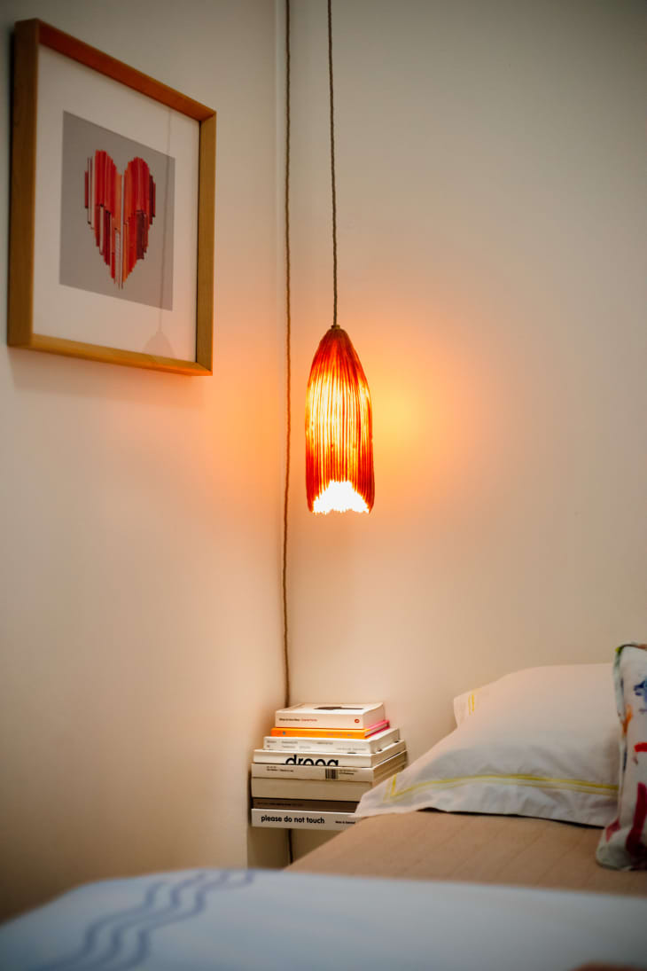 Red pendant hung above bedroom night stand.