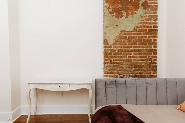A white room with exposed brick and a white table