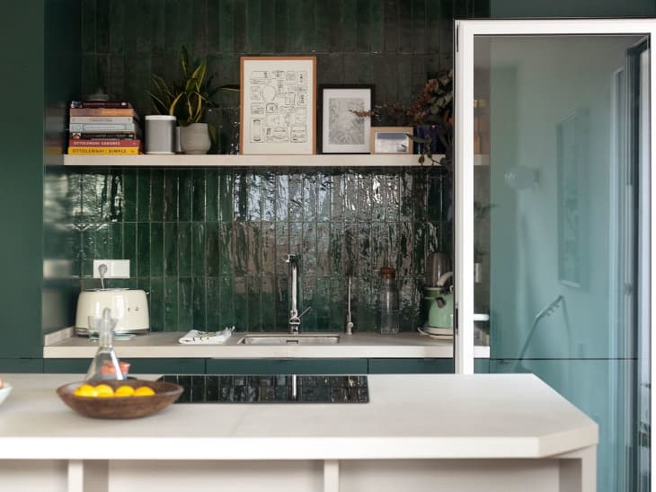 Green with green cabinets, green backsplash, and a white island.