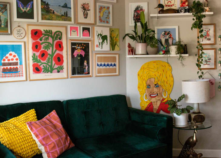 A gallery wall above a green fabric couch.