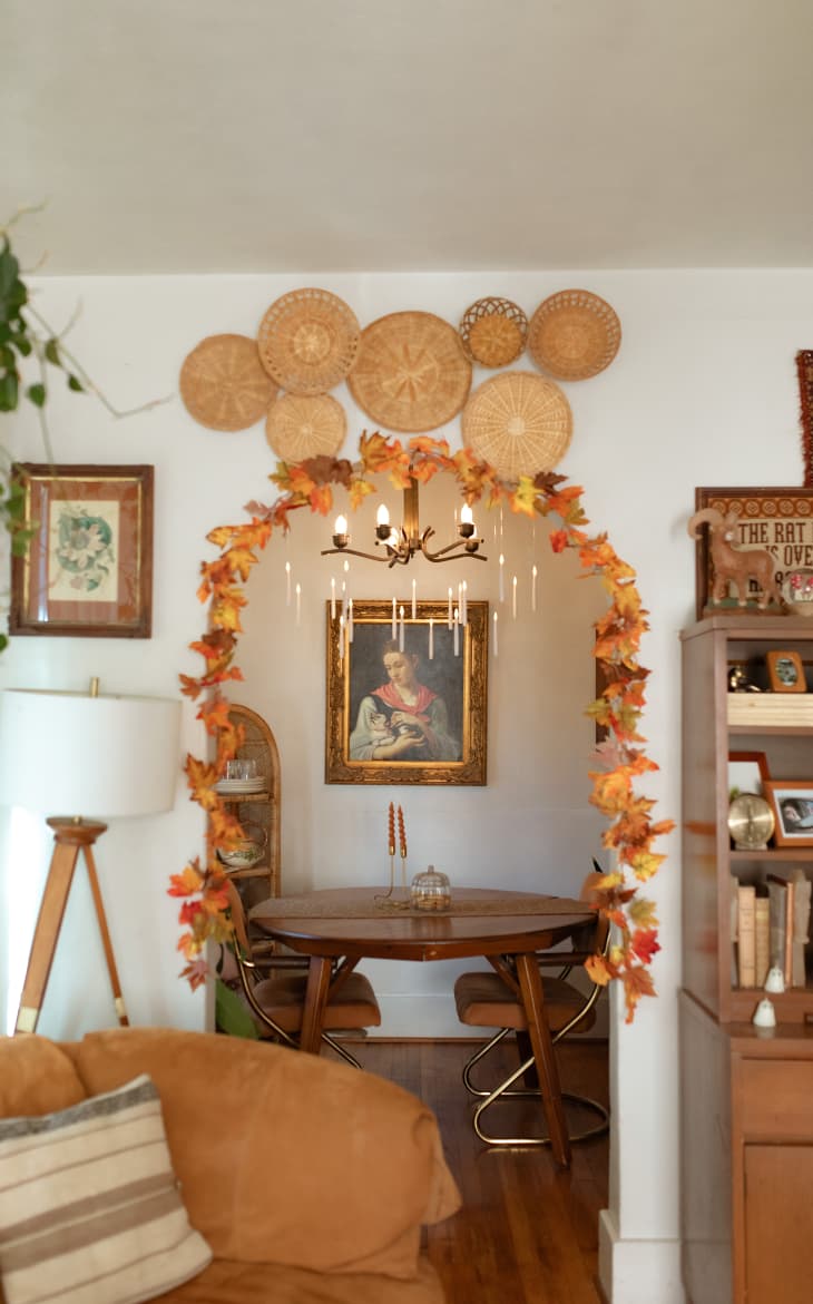 view from living room into dining room through arched doorway decorated by fall leaves