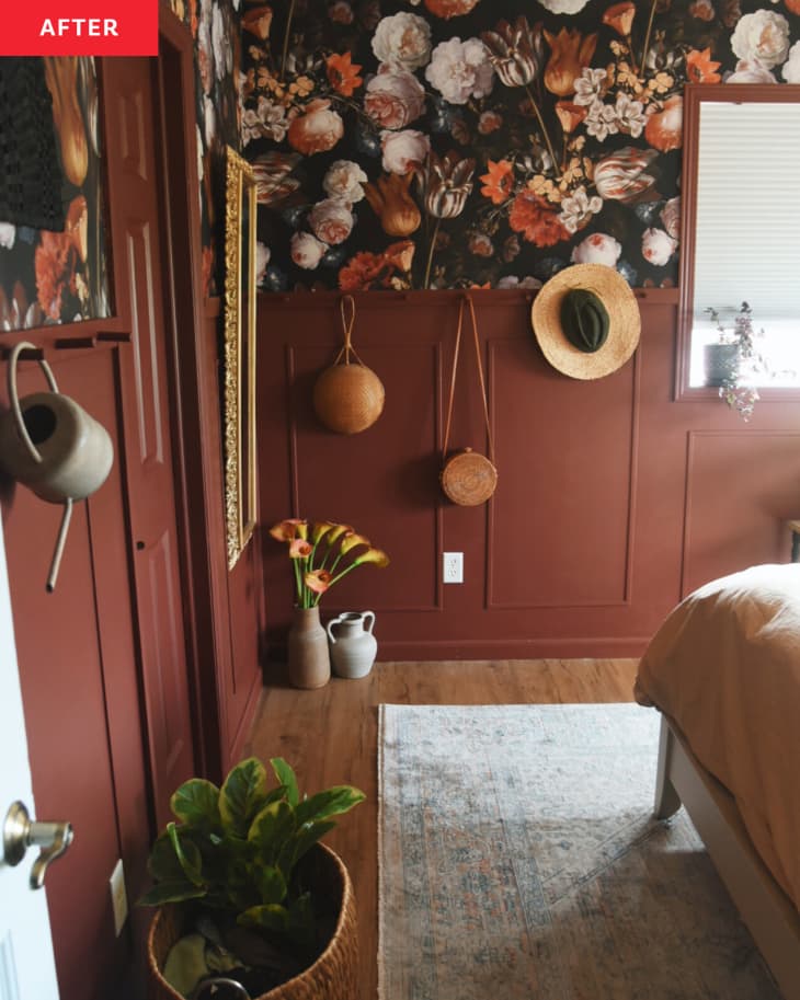 Bedroom with burnt sienna or rust colored walls with floral accent wallpaper and warm accents.