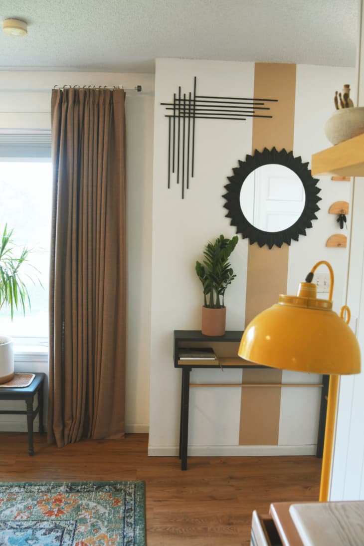 entryway area with off white walls with paint stripe details, and pops of black and yellow