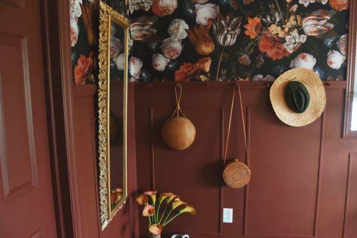 Bedroom with burnt sienna or rust colored walls with floral accent wallpaper and warm accents