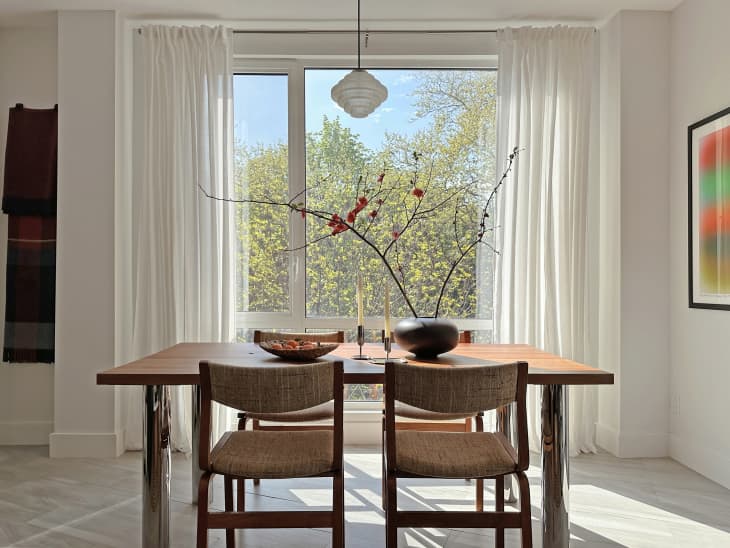 A decorated dining room table made of wood next to a large window.