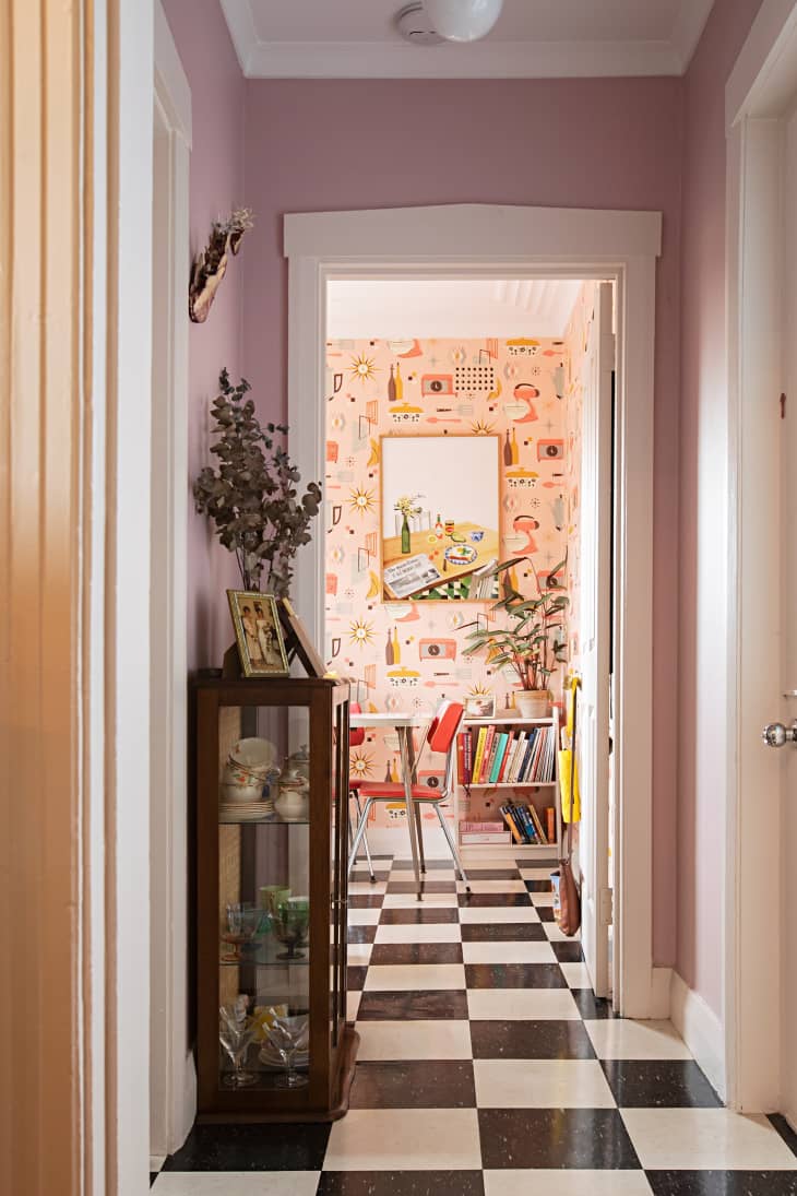 A checkered board hallway leads to a room with pink retro graphics.