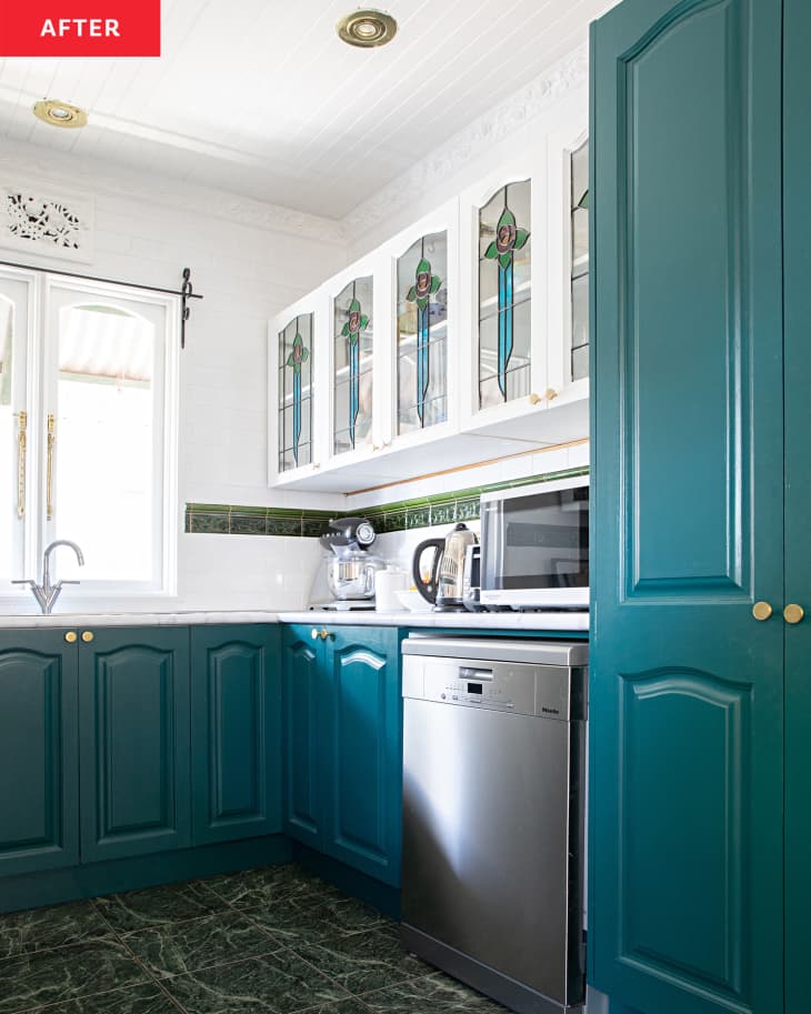 white kitchen after renovation with blue cabinets and stained glass accents