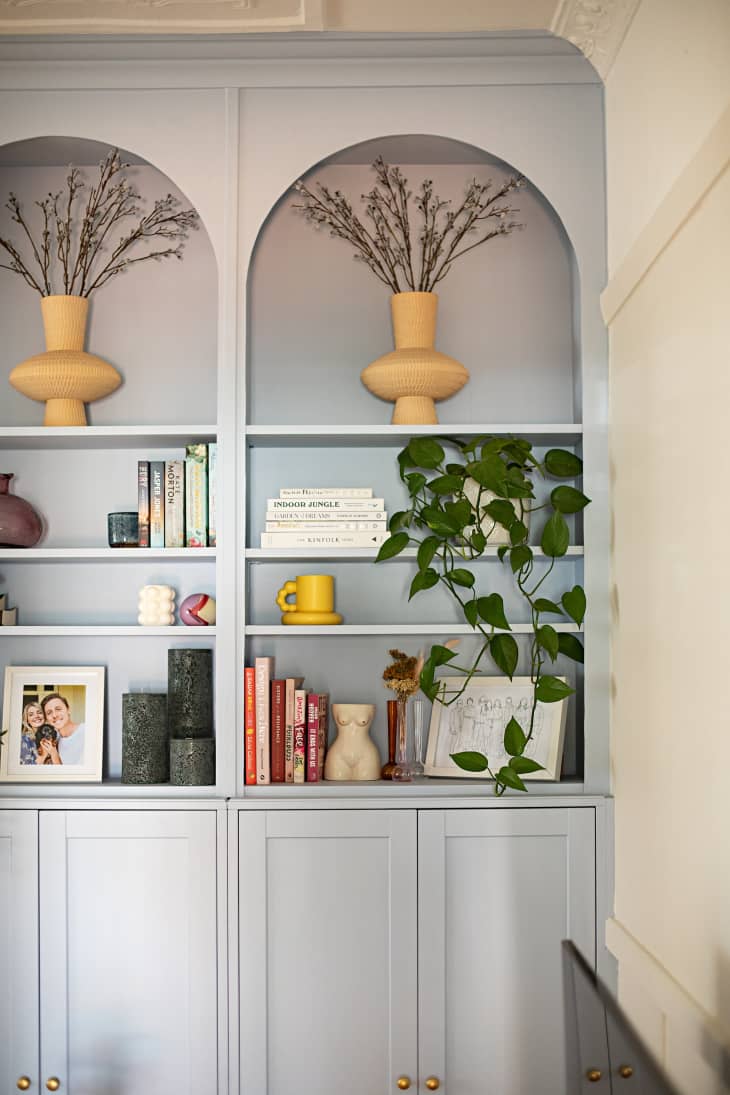 Light blue built-in bookshelf and cabinets in white living room.