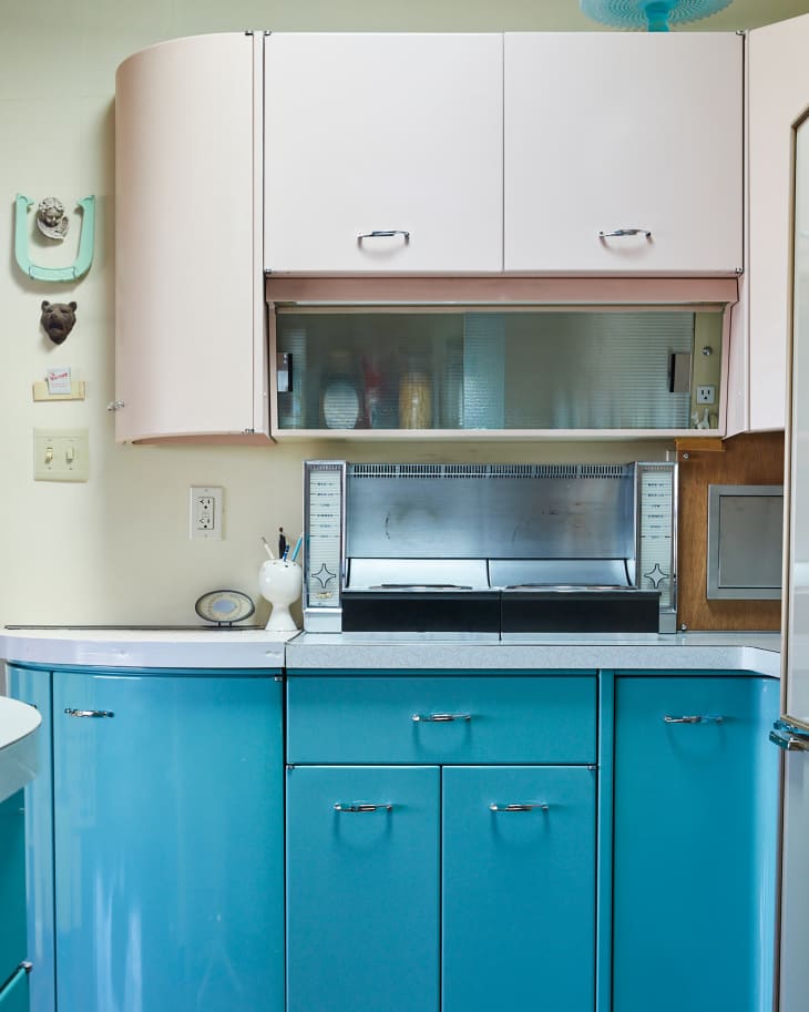 Vintage breadbox on counter of mid century modern pink and blue kitchen.