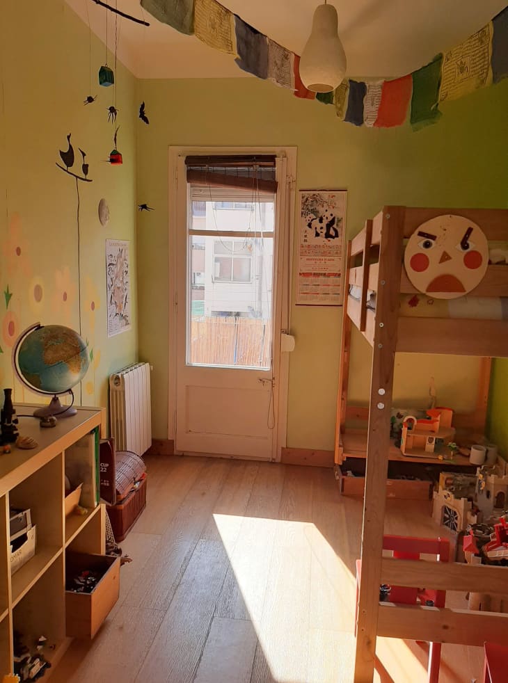 Green kids playroom with lots of toys and wood furniture