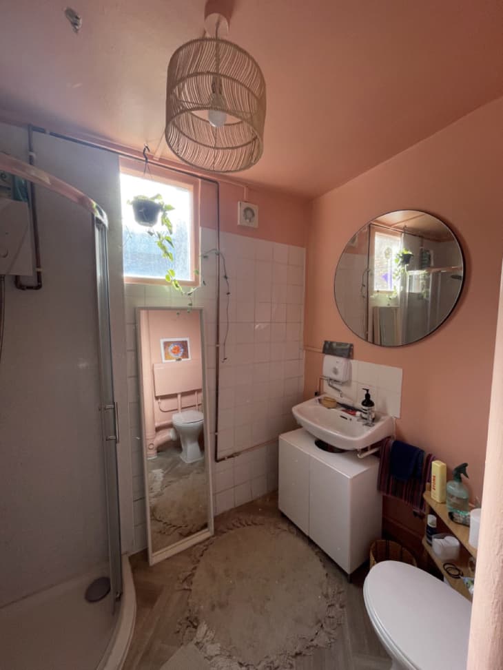 peach bathroom with round mirror