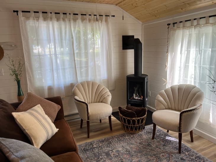 Accent chairs near fireplace in newly renovated guesthouse.