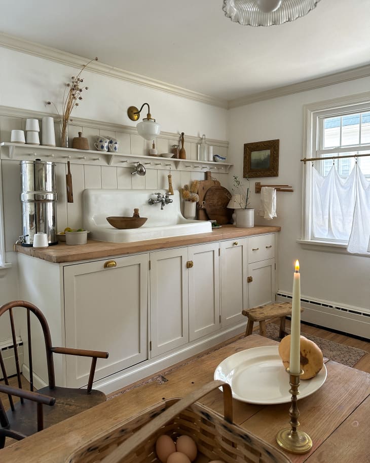 Farmhouse sink in neutral kitchen with butcher block countertops.