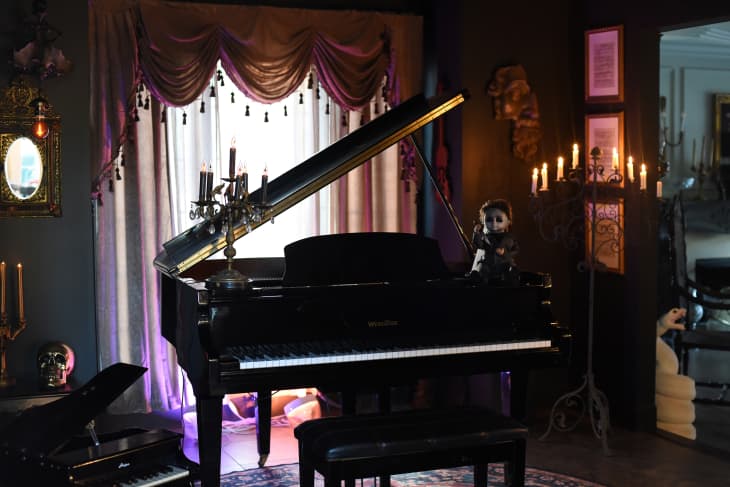 Piano in candlelit halloween themed room.