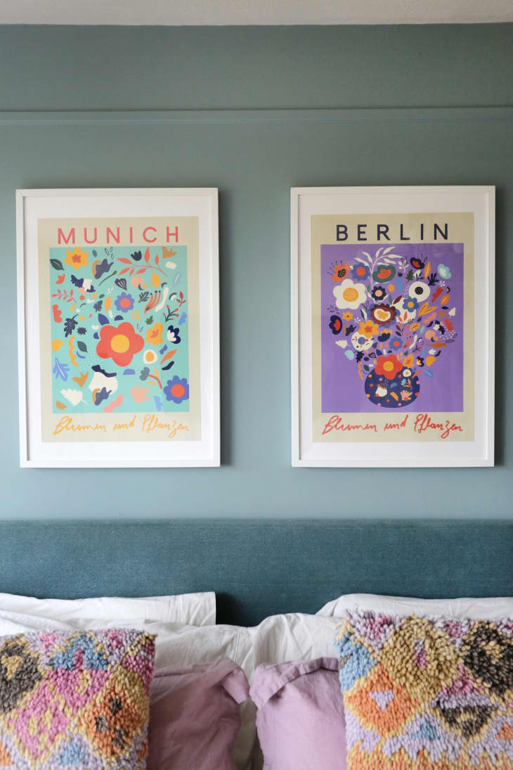 Colorful art prints behind bed.