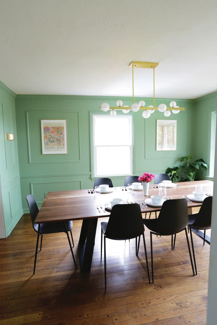 Large dining room table in green painted dining room.