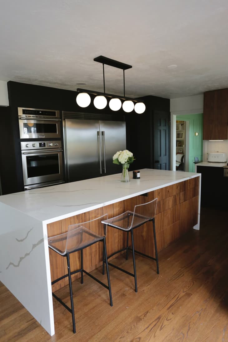 Linear pendant hung over waterfall kitchen island.