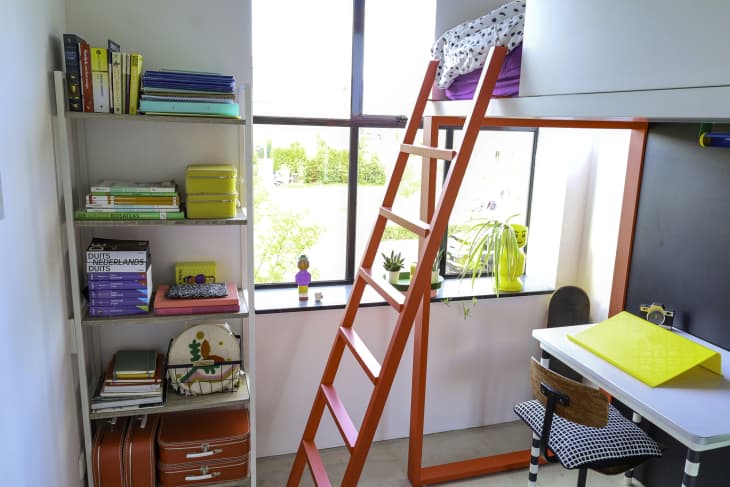A red ladder to a bunk bed in a child's room.