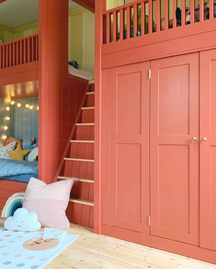 Coral, yellow, and blue kids bedroom with hideout bunk bed with stair, and a large closet