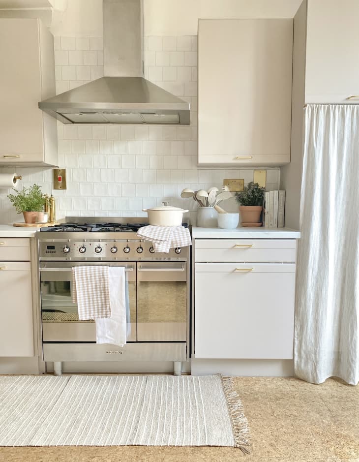 white kitchen with pale gray cabinets, white tile backsplash, and carpet