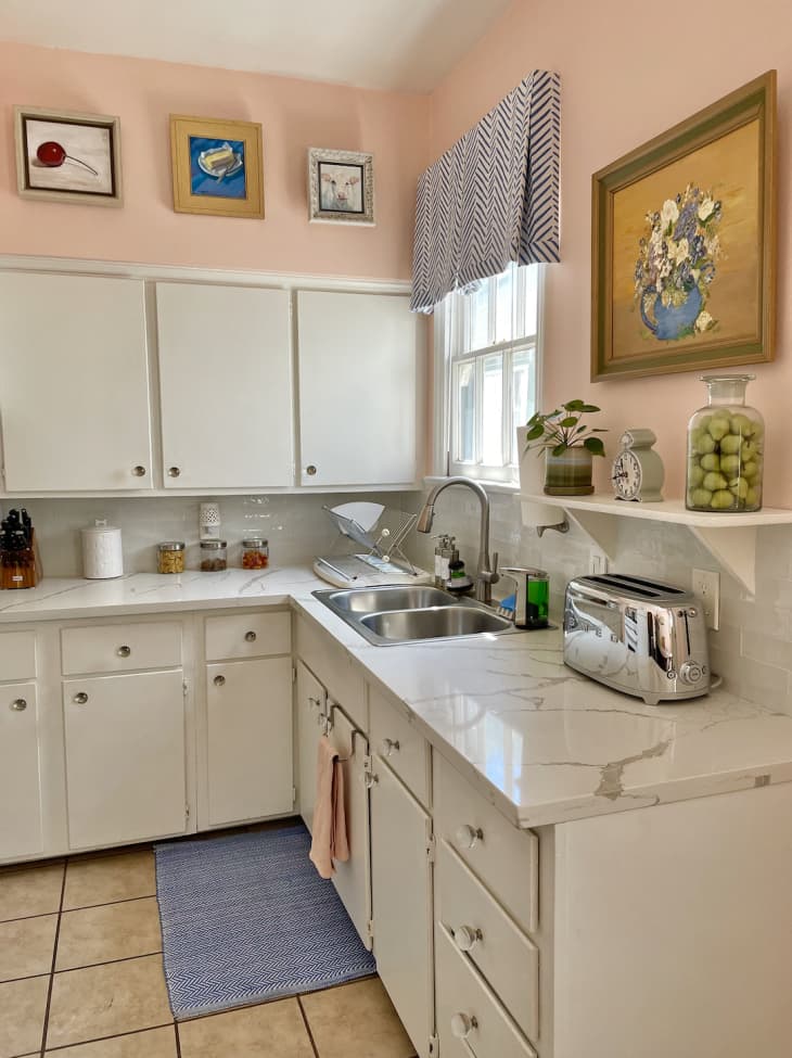 pale peach kitchen with white cabinets and tile floor