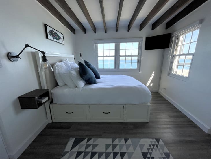 bedroom with large wood beams across ceiling and storage bed