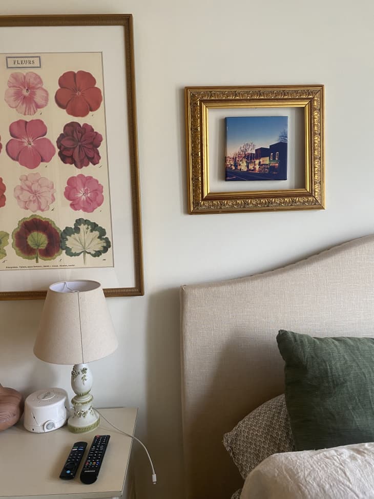 Detail of bedside table and art in white bedroom