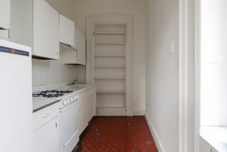 A white kitchen with tile floor